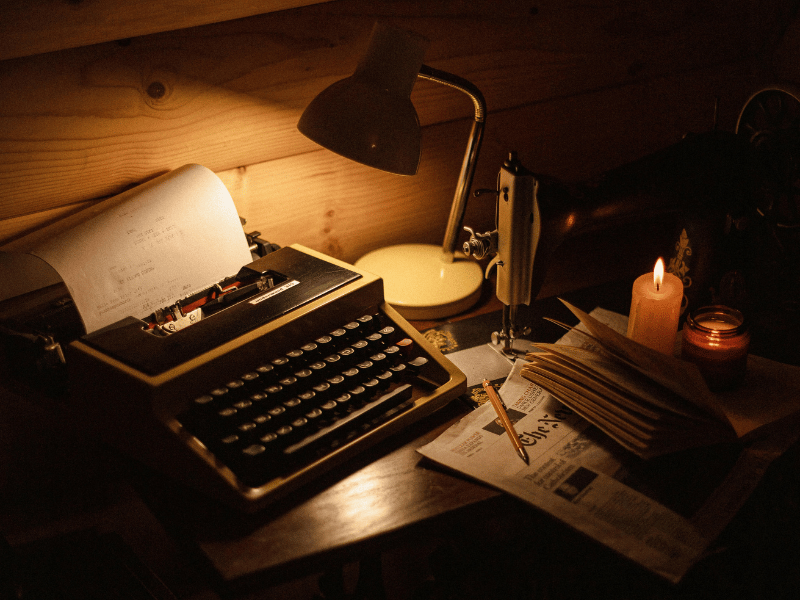 a typewriter and a lamp on a desk